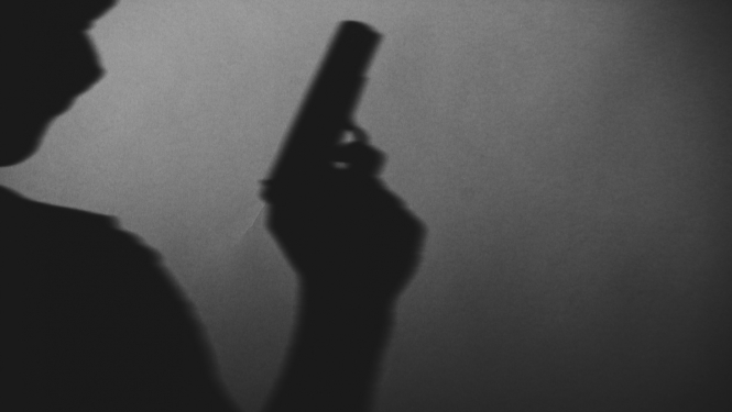 Cilvēka siluets ar ieroci rokā