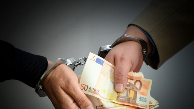 Ar rokudzelžiem sasaistītas divas rokas, kas tur daudz 50 eiro banknotes