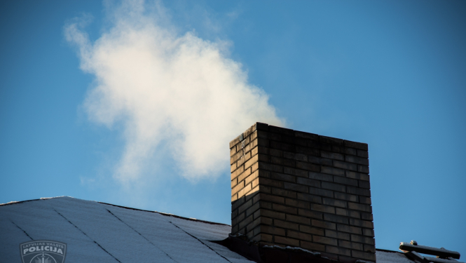 Apsnidzis mājas jumts, no skursteņa kūp dūmi