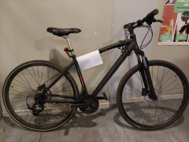 velosipēds melnā krāsā atstutēts pret sienu