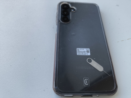 mobilais telefons Samsung tumšā krāsā ar caurspīdīgu silikona vāciņu
