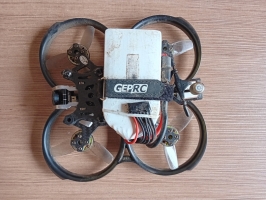 Uz gaišas lamināta grīdas novietos paštaisīts drons kvadrokopters