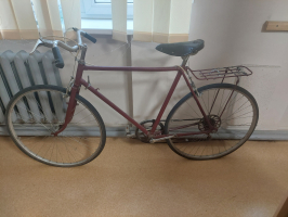 velosipēds tumši sarkanā krāsā bez kreisā pedāļa