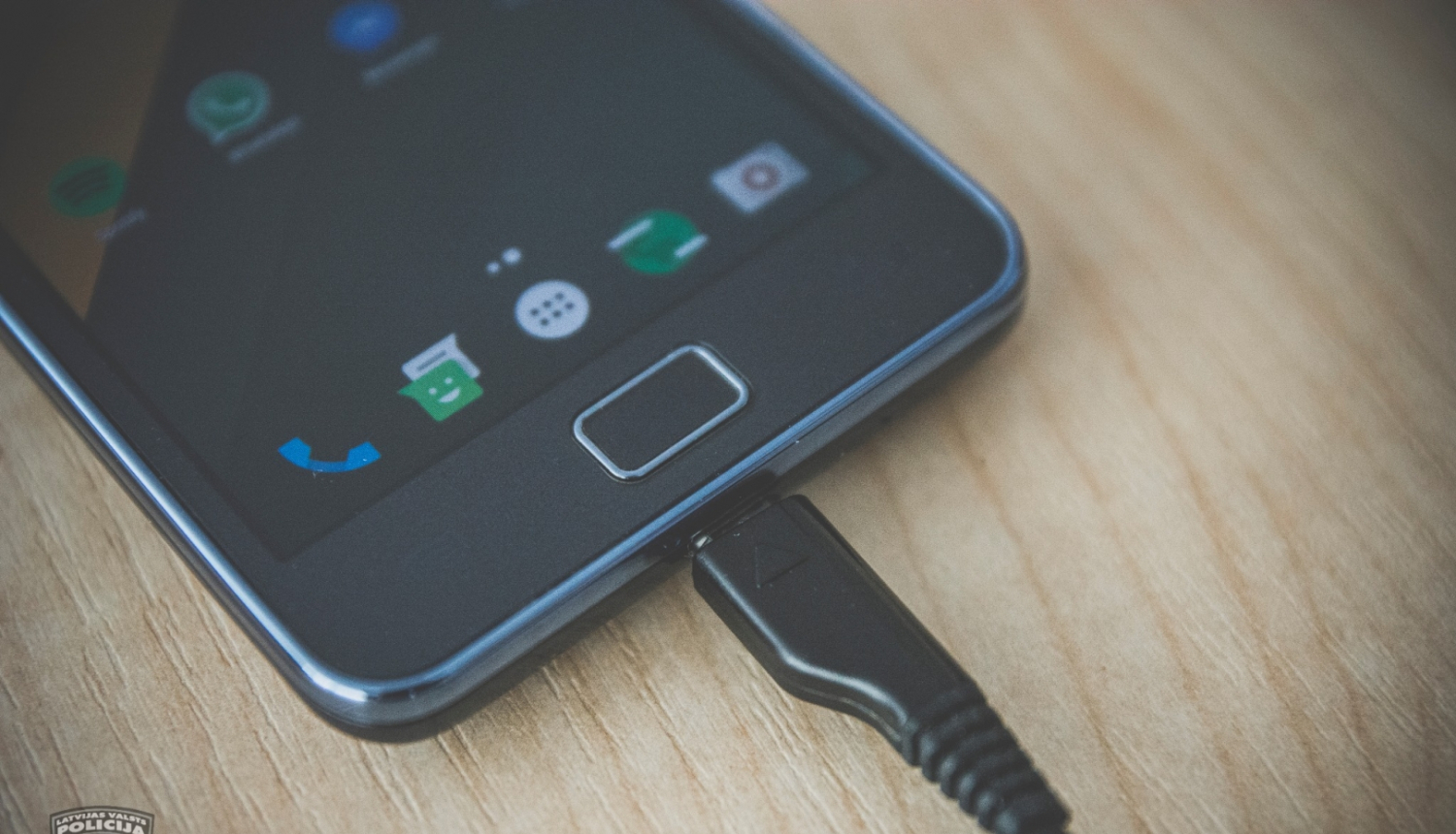 Mobilais tālrunis, kas pievienots pie lādētāja