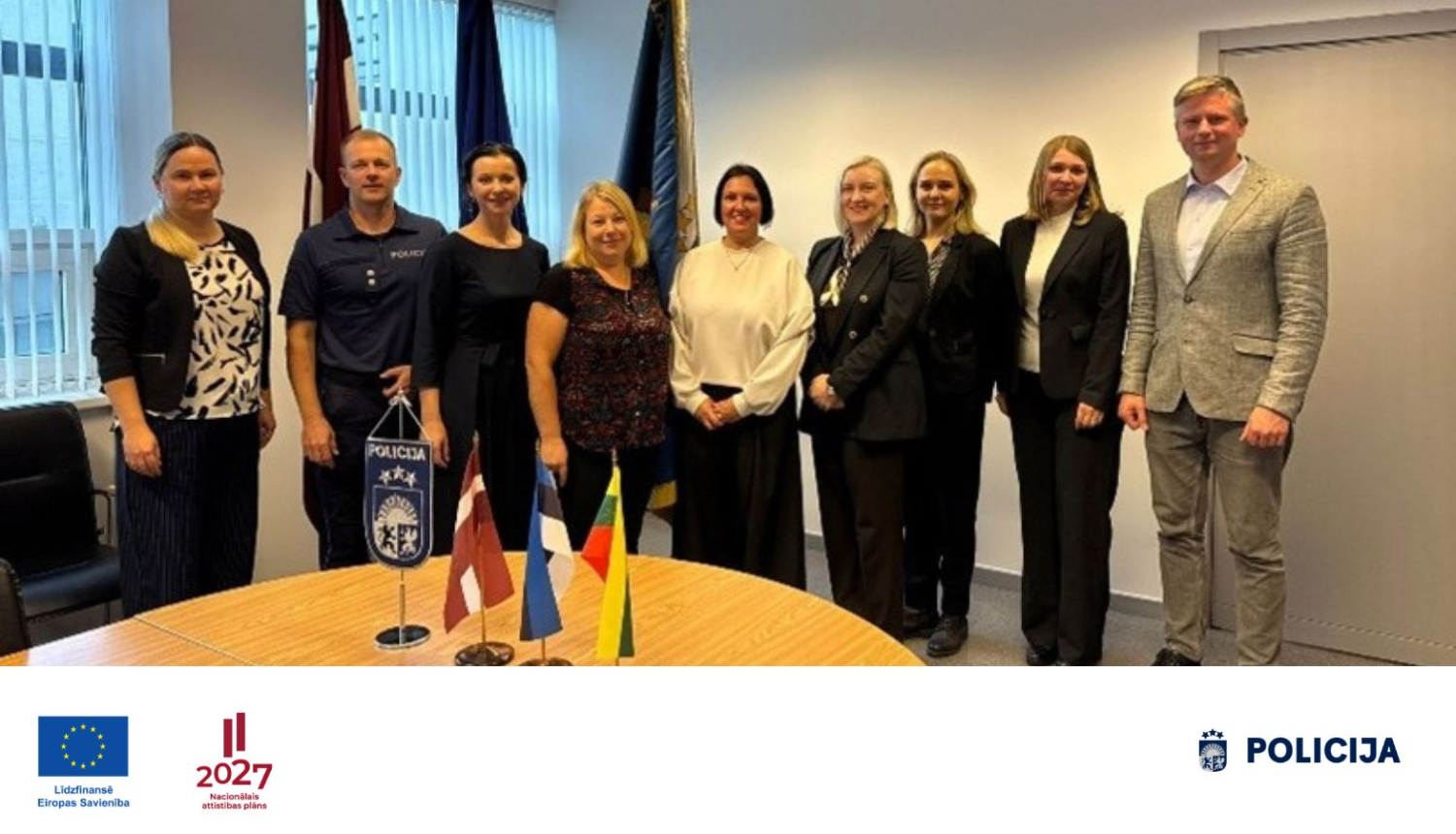 Valsts policijas pārstāvji un sadarbības partneri kopīgā grupas foto stāv sanāksmju telpā 