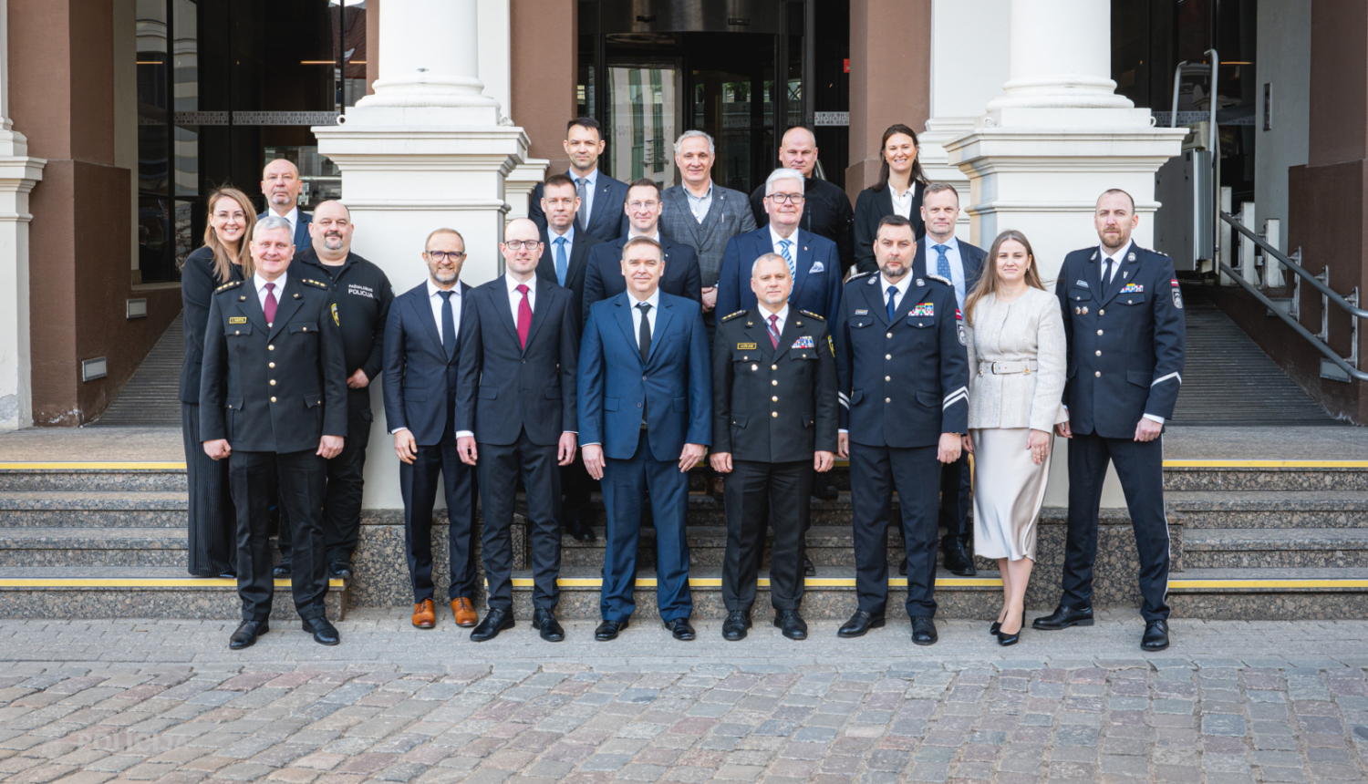 Valsts iestāžu un dienestu pārstāvju kopbilde pie reprezentablas ēkas ieejas