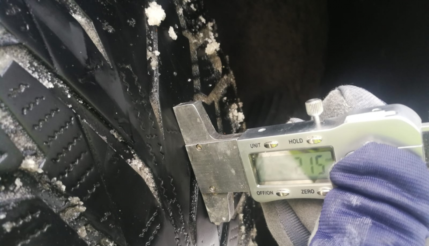 Mašīnas riepas protektora dziļuma pa®baude, kurā uzrādās 2,15