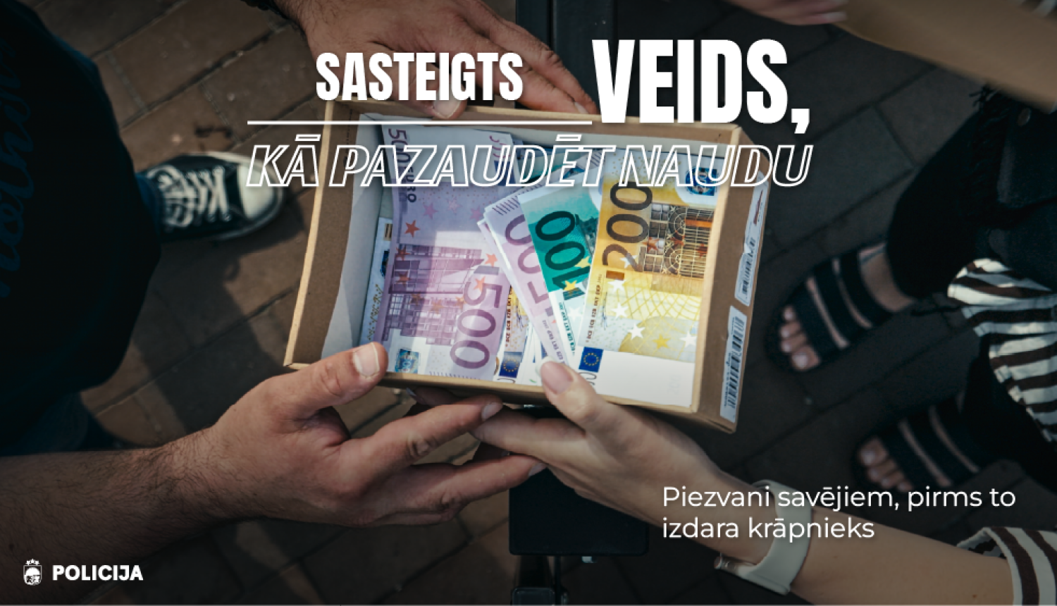 Reklāmas vizuālis par telefonkrāpšanu, divi cilvēki tur atvērtu kasti ar eiro banknotēm, virsū uzraksts “Sasteigts veids, kā pazaudēt naudu”, apakšā aicinājums “Piezvani savējiem, pirms to izdara krāpnieks”