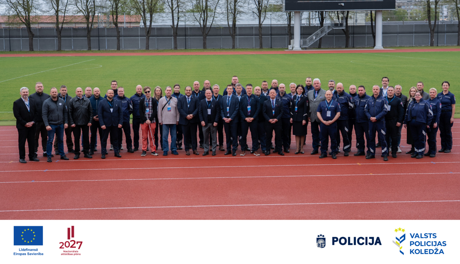Grupas foto stadionā, kurā redzami Valsts policijas, Valsts policijas koledžas un sadarbības partneru pārstāvji
