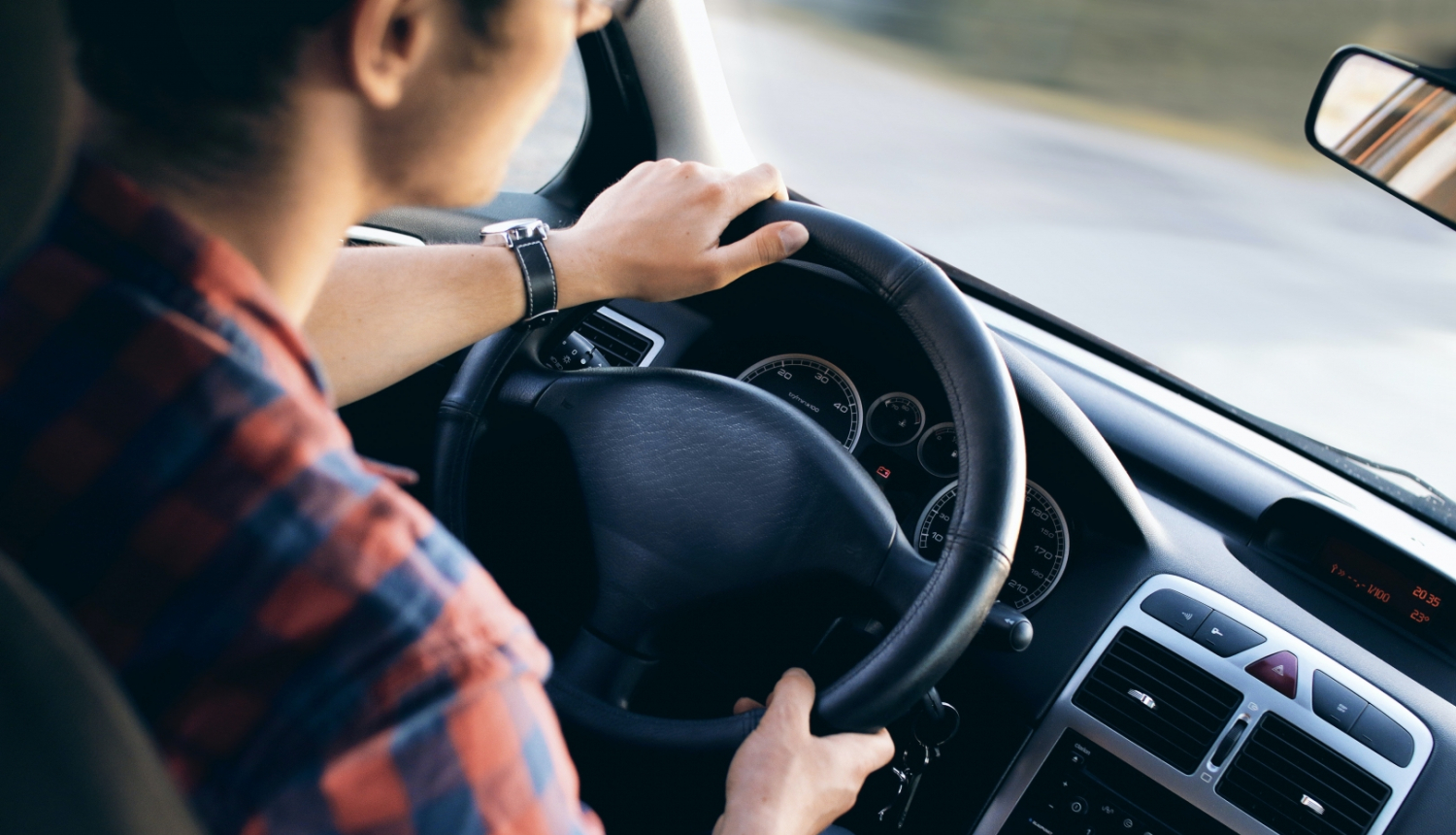 Autobusa vadītājs no mugurpuses nofotografēts pie transportlīdzekļa stūres