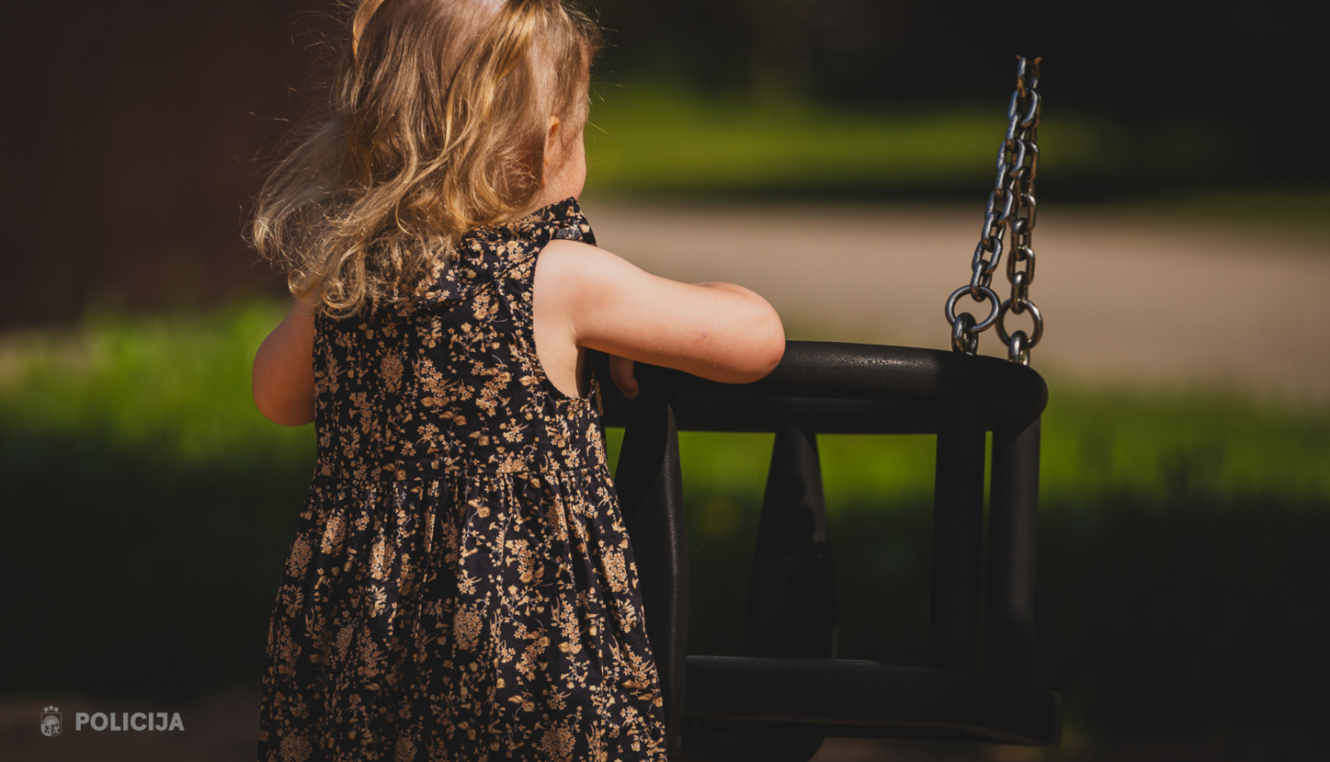 maza meitenīte rotaļulaukumā pie šūpolēm