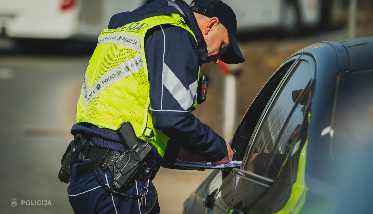 policists pieliecies pie transportlīdzekļa, kuru apturējis par kādu pārkāpumu