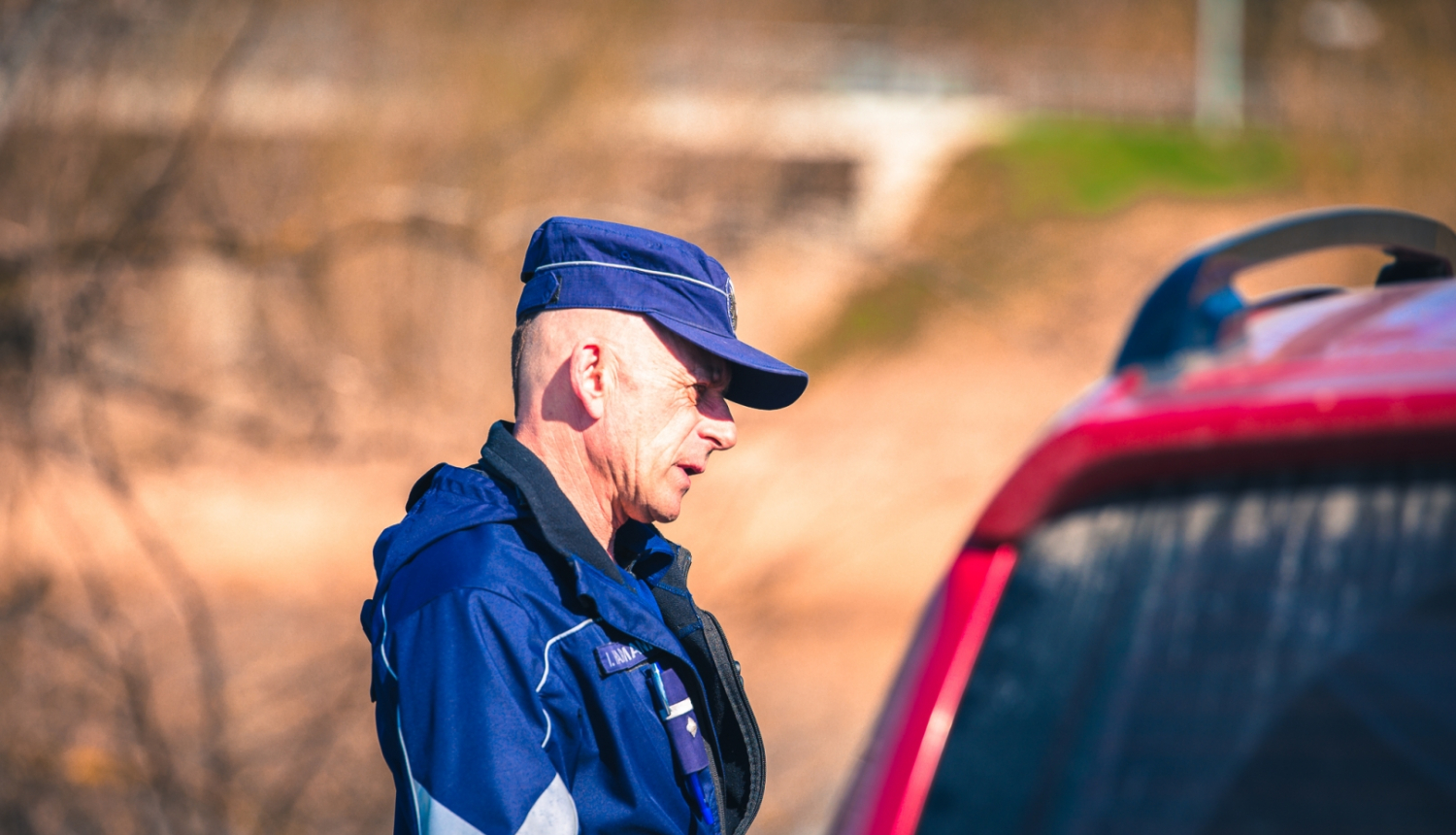 Valsts policijas darbinieks pie automašīnas