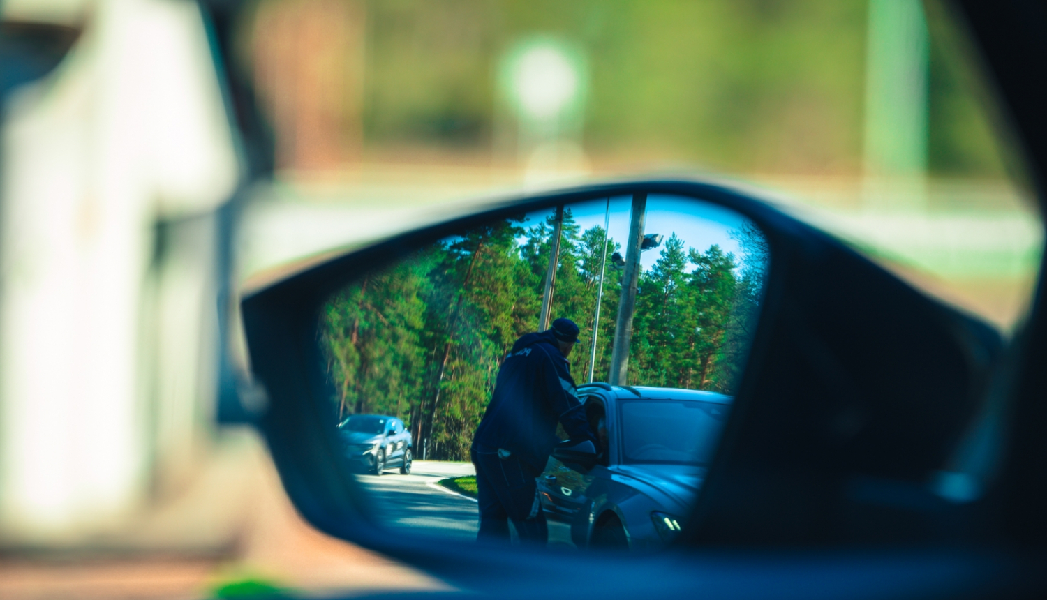 Valsts policijas darbinieks pie automašīnas