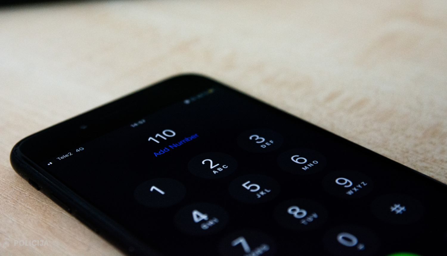 Viedierīce, kuras ekrānā attēlots telefona numurs 110
