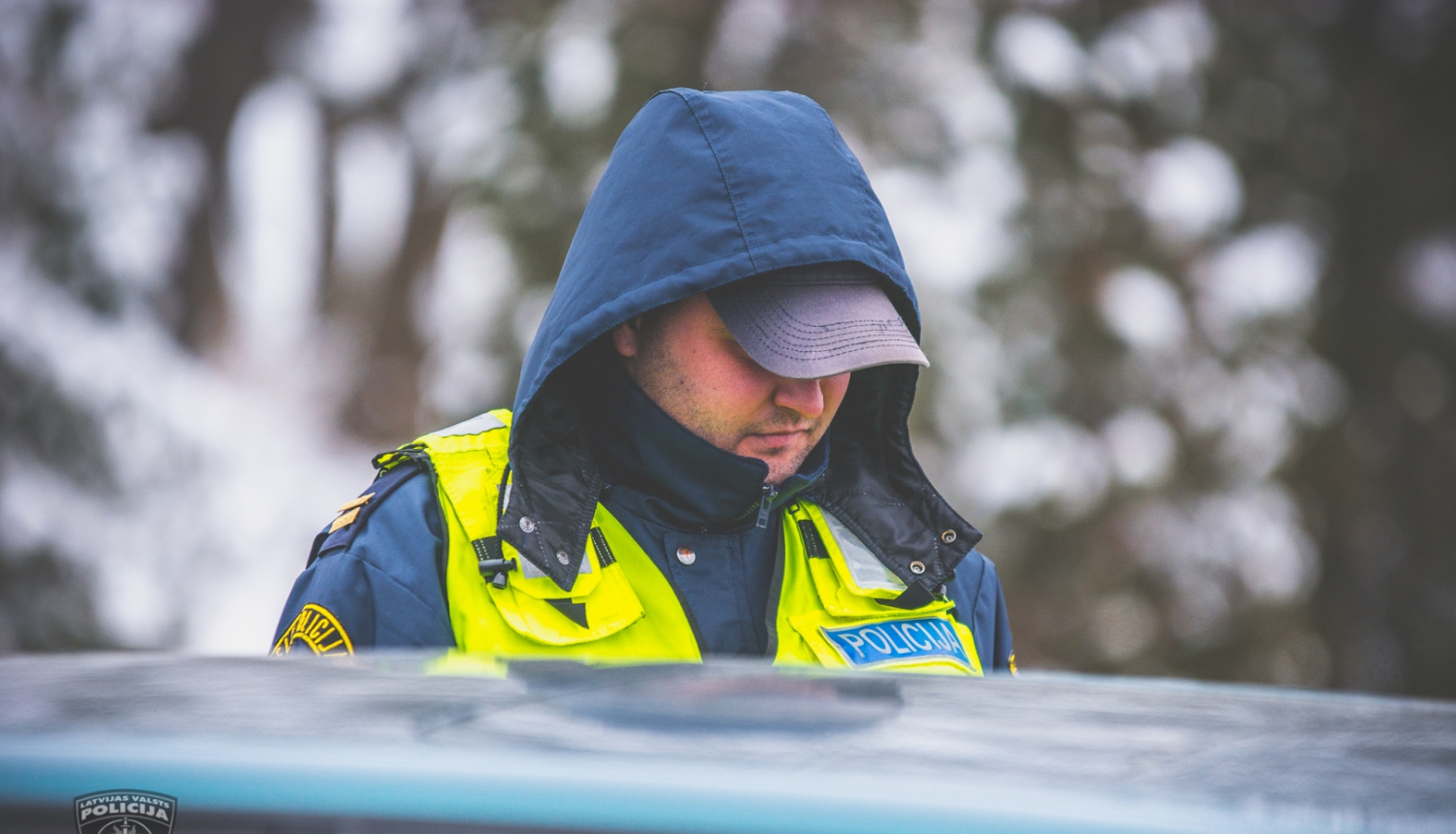 Ceļu policists pie automašīnas