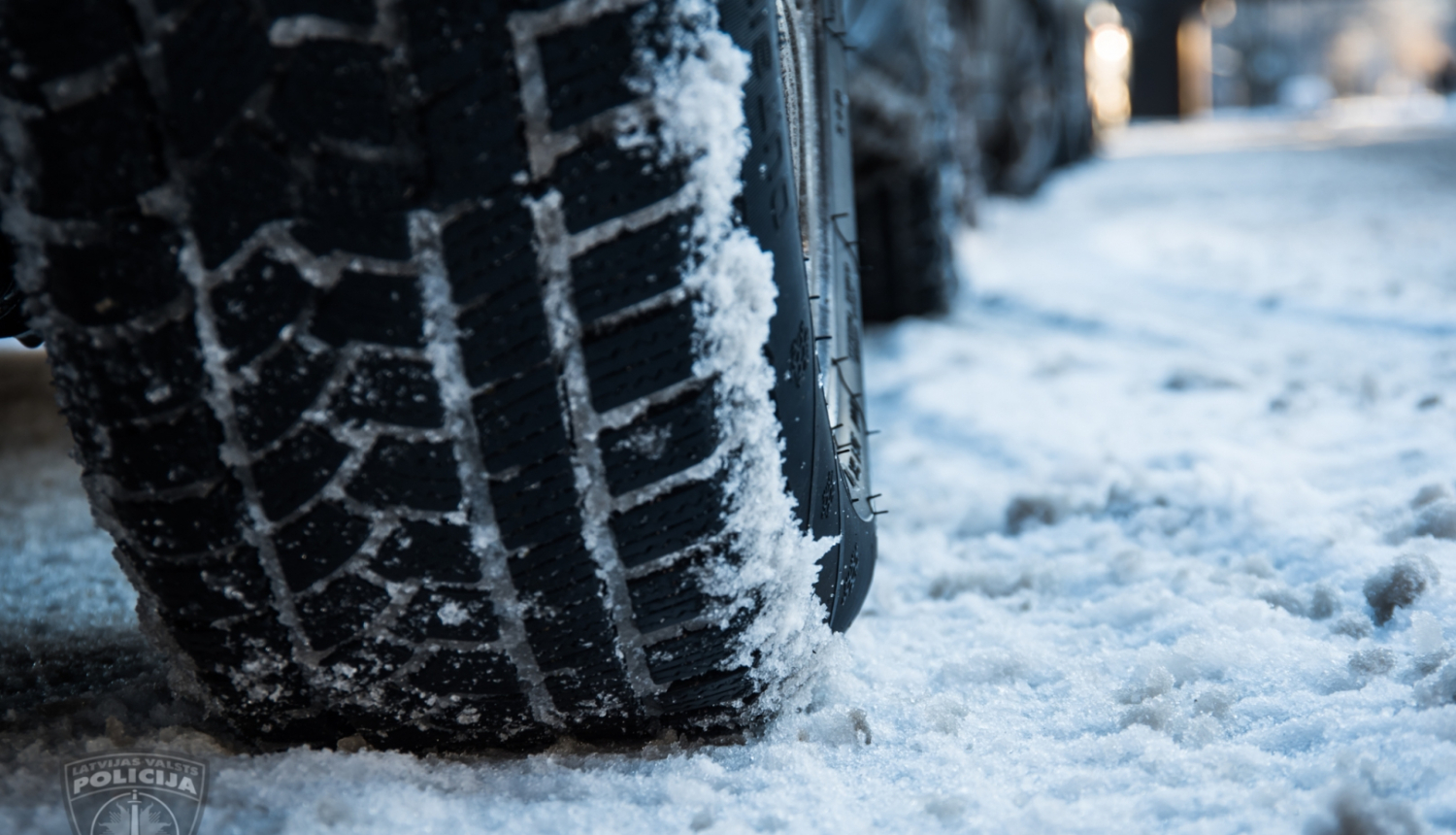 Automašīnas riepa tuvplānā uz sniegota ceļa