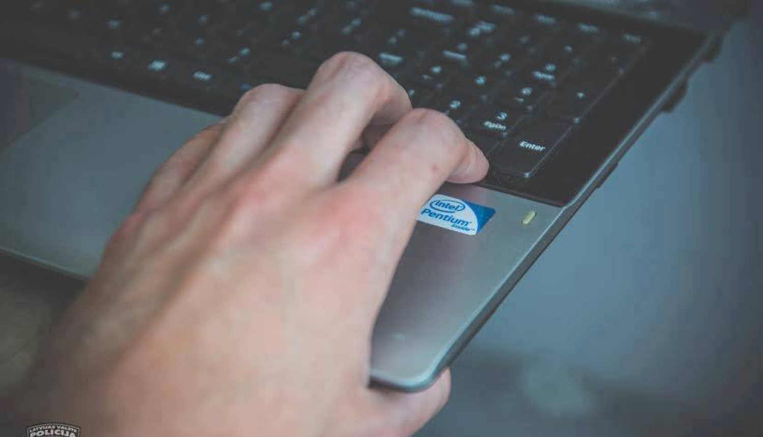 Cilvēks ar kreiso roku piepacēlis portatīvā datora apakšējo labo stūri