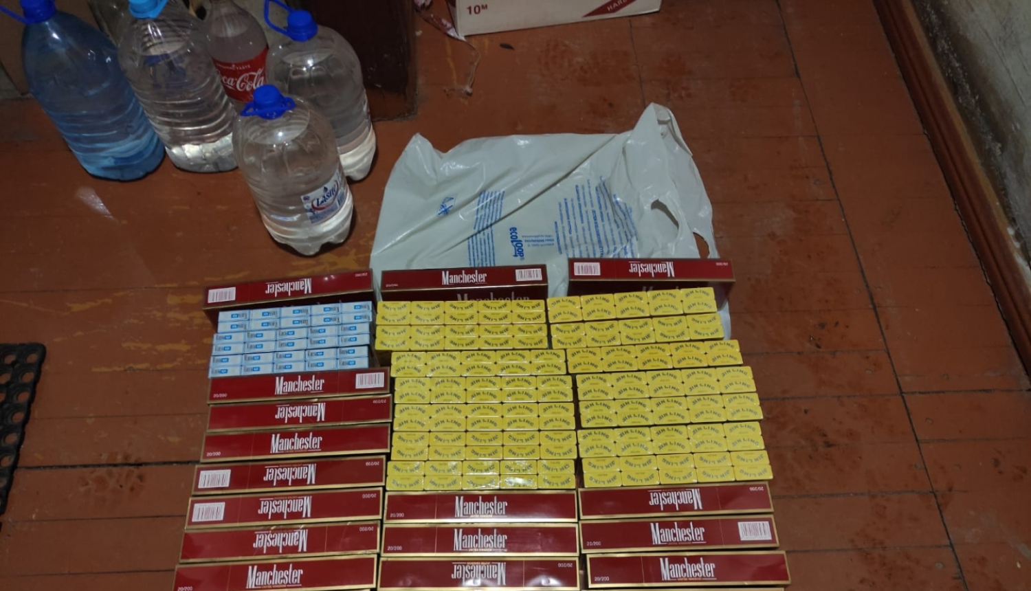 Cigarešu bloki un vairākas plastmasas pudelēs iepildīts caurspīdīgs šķidrums