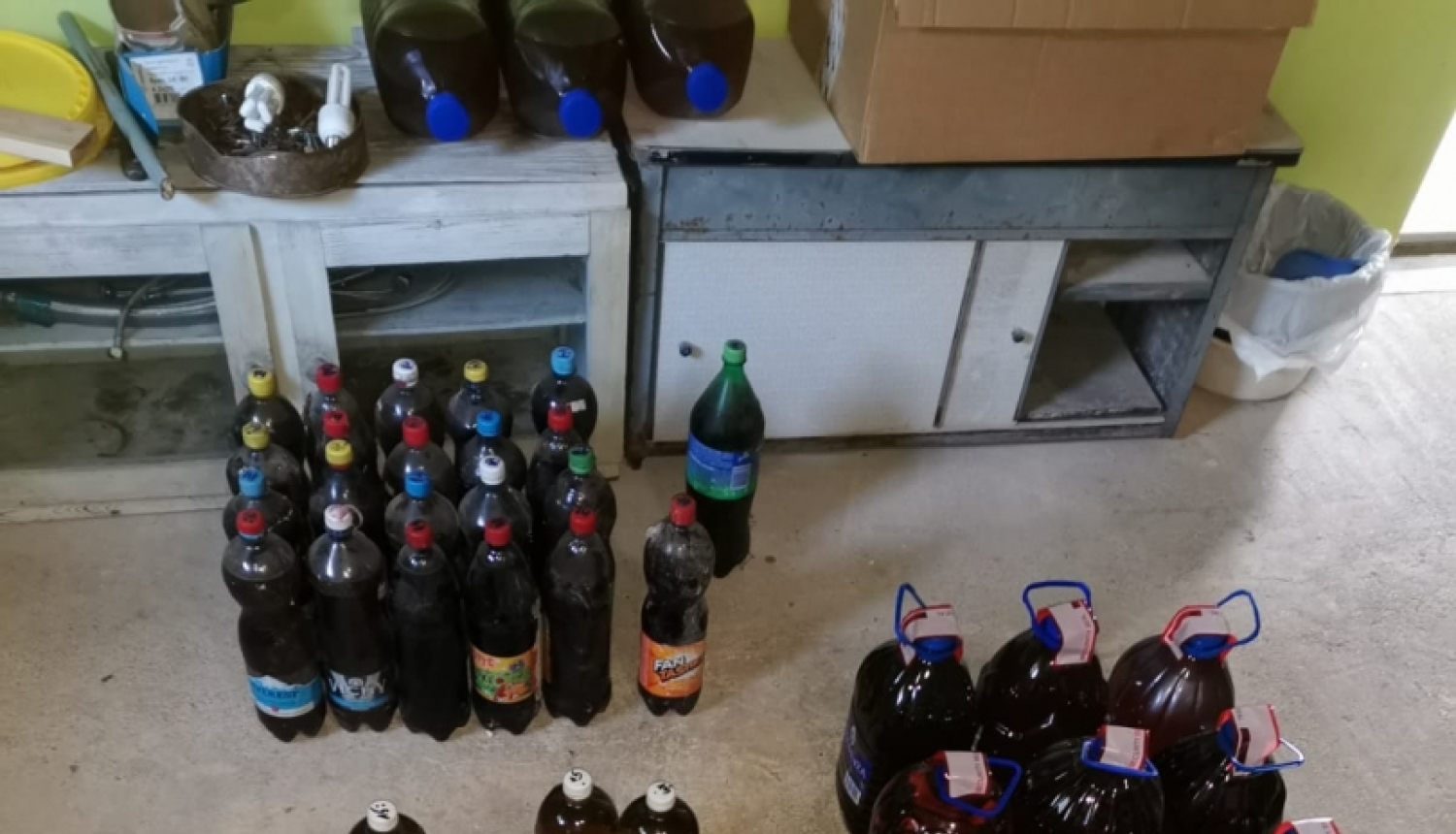 Uz grīdas dažāda tilpuma pudeles