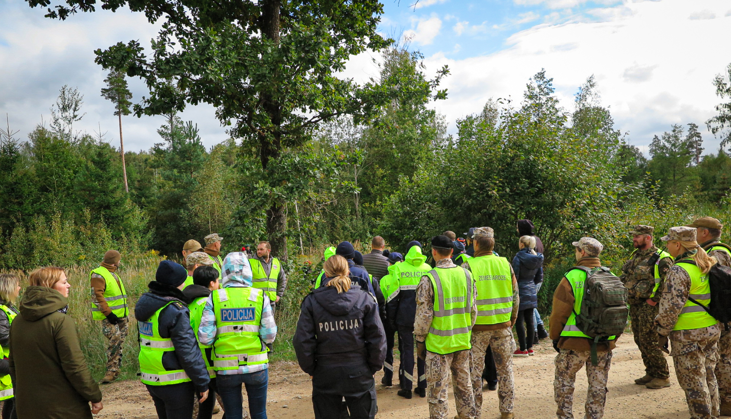Policisti un zemessargi sapulcējušies pie meža, pirms došanās iekšā meklēt bezvēsts pazudušu ogotāju