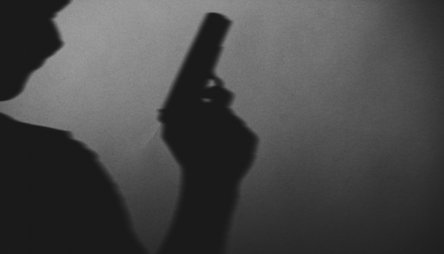 Cilvēka siluets ar ieroci rokā