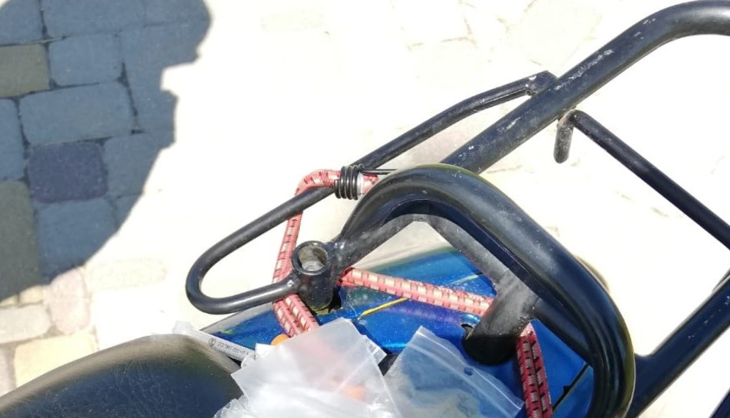 Uz zila mopēda redzamas vairākas šļirces un iepakopums ar baltu, pulverveida vielu