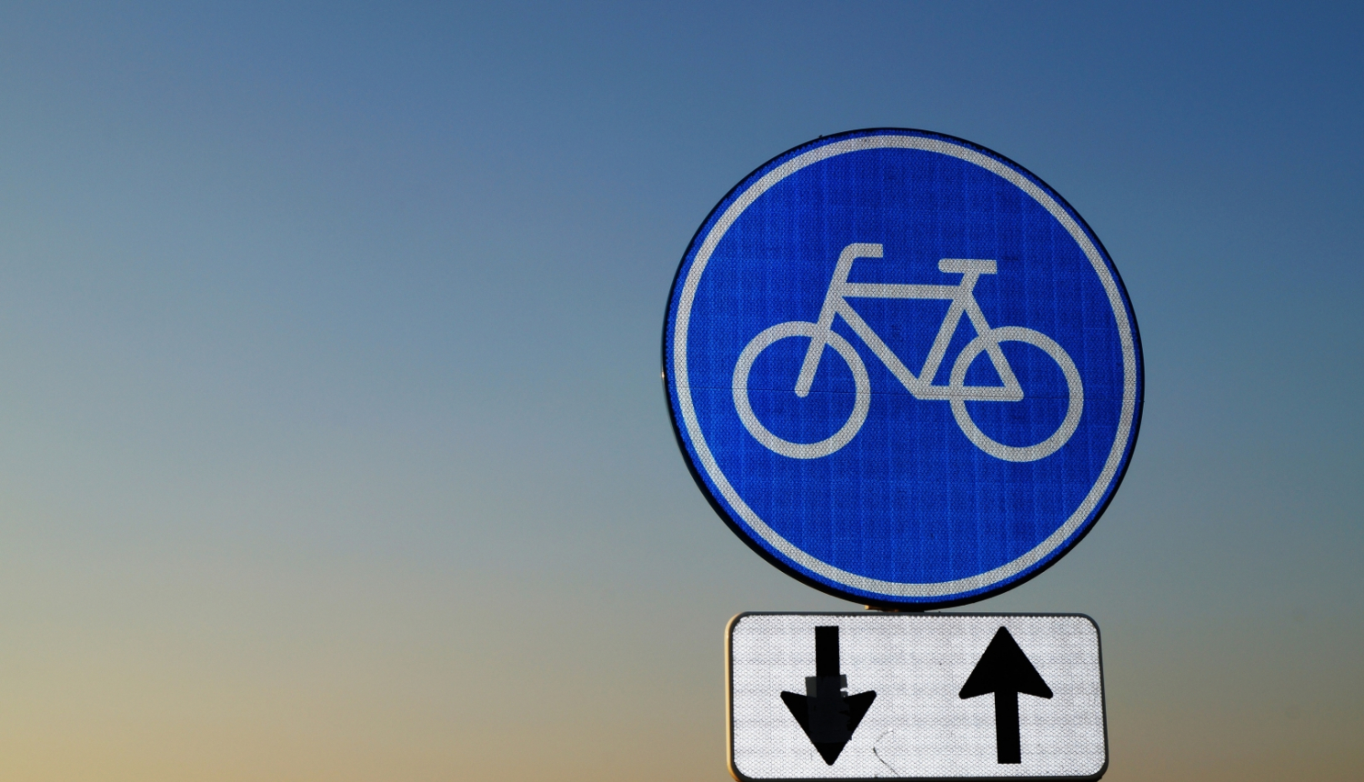 Uz debesu fona redzama ceļazīme "Velosipēdu ceļš" ar darbības virzienu papildzīmi 