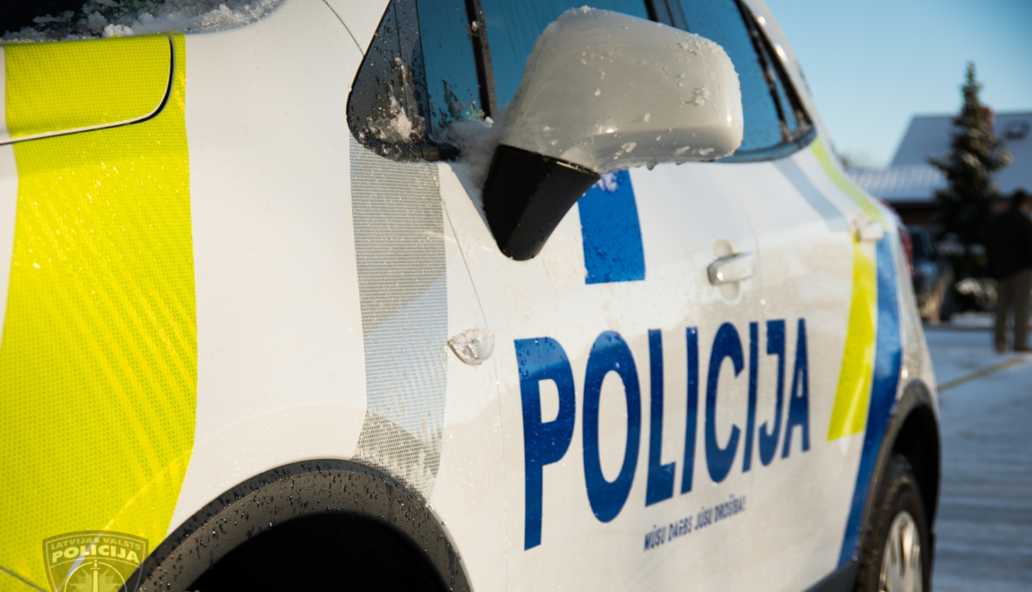 policijas uzraksts uz mašīnas sāna