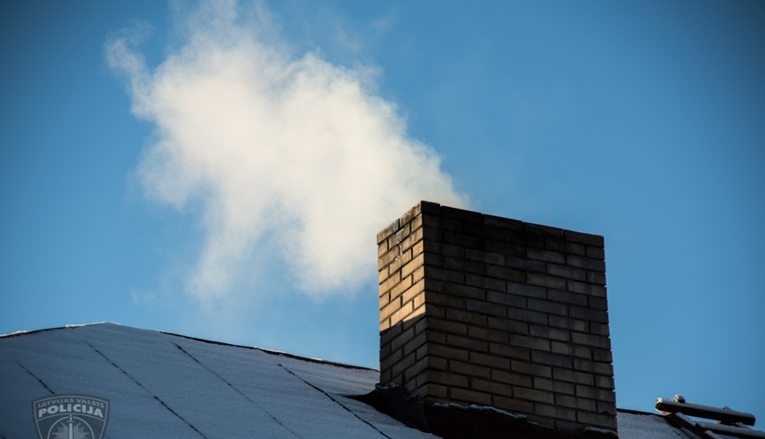 Apsnidzis mājas jumts, no skursteņa kūp dūmi