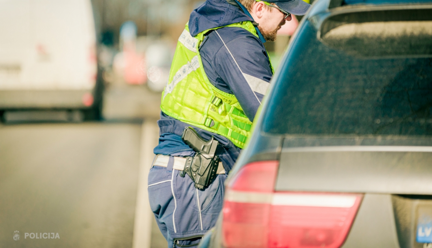 Valsts policijas amatpersona pie automašīnas