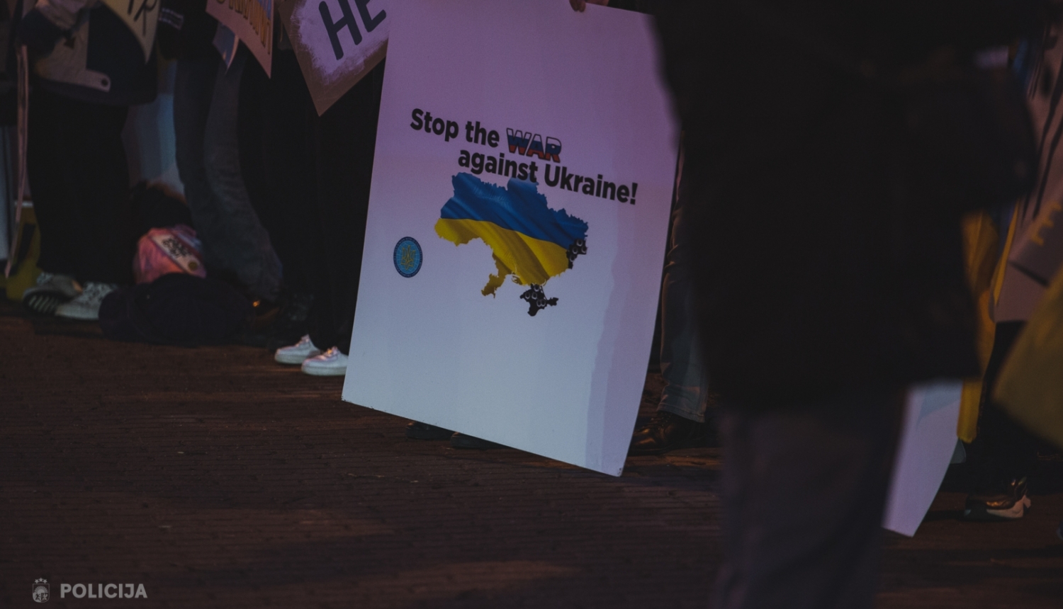 Plakāts ar uzrakstu "Stop war against Ukraine" tulkojumā - apturiet karu pret Ukrainu