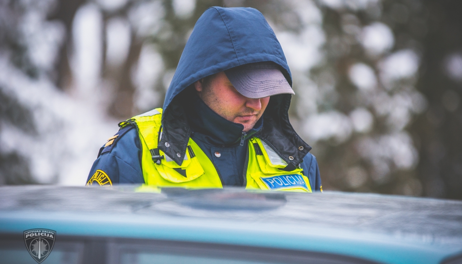 Ceļu policists pie automašīnas