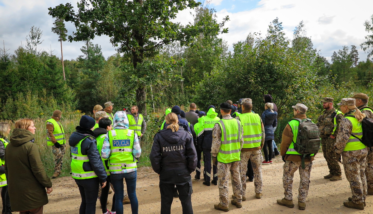 Policisti un zemessargi sapulcējušies pie meža, pirms došanās iekšā meklēt bezvēsts pazudušu ogotāju