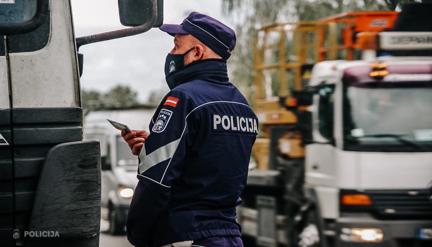 Valsts policijas darbinieks pie kravas mašīnas stāv